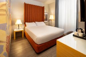 a bedroom with a bed with a large headboard at Holiday Inn Milan Garibaldi Station by IHG in Milan