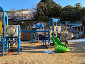 a playground with a green slide and a green slide at のどかな風景と綺麗な星空の宿 "キノイロ ミニマル" "Kinoiro Minimal" in Ainan