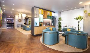 a waiting room with blue chairs and a table at Holiday Inn Milan Garibaldi Station by IHG in Milan