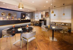 a dining room with two tables and chairs at Holiday Inn Milan Garibaldi Station by IHG in Milan
