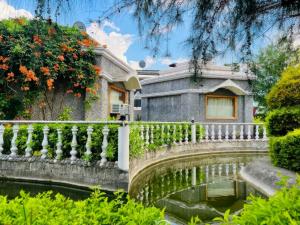 an old house with a fence next to a pond at MJ Funcity Water Park & Resort in Lucknow