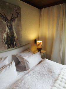 a bedroom with a bed with a picture of a deer at Schwarzberghof in Dachau