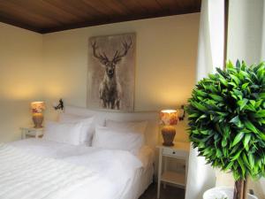 a bedroom with a bed and a painting of a deer at Schwarzberghof in Dachau