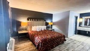a hotel room with a bed and two lamps at Studio 6 Suites Albany, GA in Albany