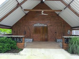 a wooden garage with a wooden door and a hanger at CHALET - SCEA 2222 Site Agrotouristique in Sinnamary +2 photos