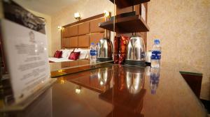 Ein Hotelzimmer mit Wasserflaschen auf der Theke in der Unterkunft Orchid Inn by WIH in Karatschi