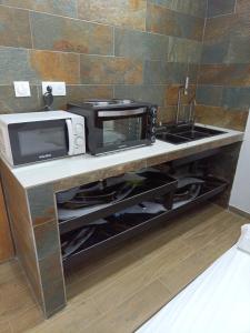 a microwave oven sitting on a counter in a kitchen at CHALET - SCEA 2222 Site Agrotouristique in Sinnamary