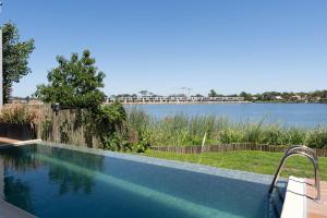 a swimming pool with a view of a body of water at Lake Life Exclusivo apartamento en Parque Miramar in Montevideo