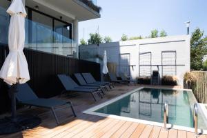 a swimming pool on a deck with chairs and an umbrella at Lake Life Exclusivo apartamento en Parque Miramar in Montevideo +13 photos