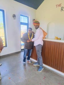 two men standing next to each other in a room at THE RiYASAT SARISKA in Ajabgarh
