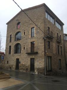 an old brick building with an american flag in the window at La Casa Vella in Navarcles