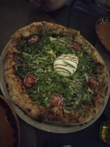 eine Pizza mit Tomaten und Gemüse auf einem Tisch in der Unterkunft Magic in Razvala