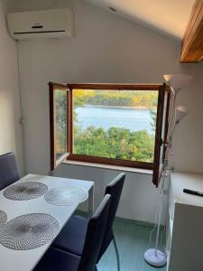 a table and chairs in a room with a large window at apartman FML Cres in Cres
