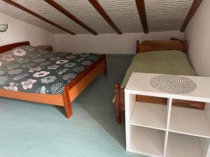 a small bedroom with a bed and a table at apartman FML Cres in Cres