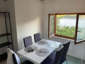 a dining room with a table with chairs and a window at apartman FML Cres in Cres
