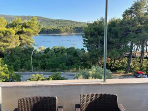 two chairs on a balcony with a view of a lake at apartman FML Cres in Cres