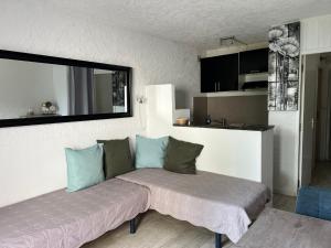 a bedroom with two beds and a mirror on the wall at Résidence les pieds dans l'eau in Porto-Vecchio