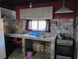 a small kitchen with a sink and a stove at La Lugarda in Cuesta Blanca