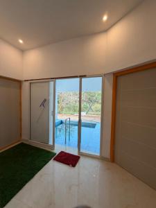 a room with a large glass door with a view of a pool at ACK River Palms - Athirappilly in Athirappilly