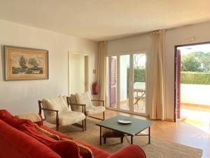 a living room with a couch and chairs and a table at Casa Manacá Vilamoura in Quarteira