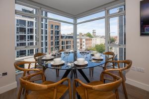 a dining room with a table and chairs and windows at Parnell Corner Apartments in Dublin
