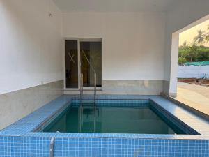 a swimming pool in a house with blue tiles at ACK River Palms - Athirappilly in Athirappilly
