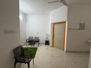 a room with chairs and a door and a green rug at ACK River Palms - Athirappilly in Athirappilly