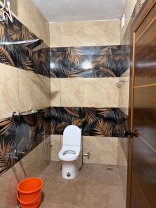 a bathroom with a toilet and black and brown wallpaper at ACK River Palms - Athirappilly in Athirappilly +5 photos