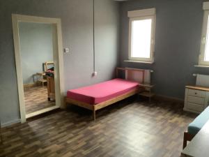 a bedroom with a pink bed in a room at Adler in Kraichtal