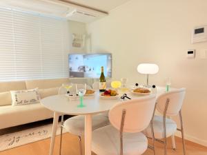 a white dining room with a white table and chairs at stable home#신축#천호역2분#KSPO#롯데월드#롯데타워#아산병원#코엑스#가족여행#장박할인 in Seoul