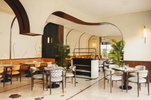 a restaurant with tables and chairs in a room at ALMA Hotel Riyadh in Riyadh