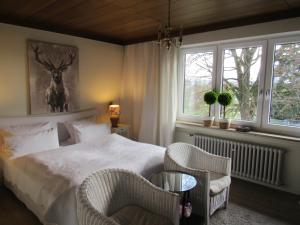 a bedroom with a bed and two chairs and a window at Schwarzberghof in Dachau