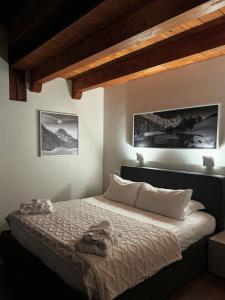 a bedroom with a large bed with two pictures on the wall at Maison Poluc - Maison Monte Rosa in Champoluc +54 photos