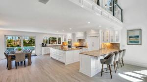 a kitchen with white cabinets and a table and chairs at Villa Saltwater Haven in East Hampton