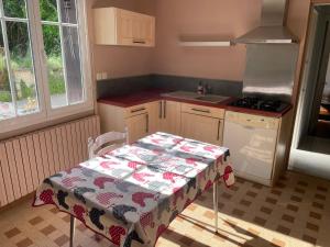 a kitchen with a table with a table cloth on it at Gîte centre coulon - Le Héron in Coulon