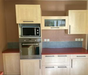 a kitchen with a stove and a microwave at Gîte centre coulon - Le Héron in Coulon +5 photos