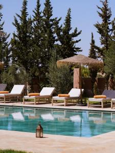 a swimming pool with lounge chairs and a umbrella at Palais Dar Souhir in Aït Bou Zguia