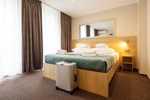 a hotel room with a bed and a suitcase at Hotel Boss in Łódź