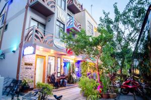 un grupo de personas sentadas afuera de un edificio en Newtown Inn, en Hulhumale