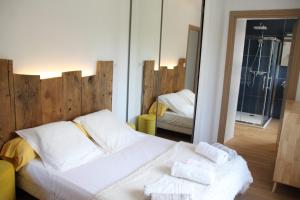 a bedroom with a white bed and a mirror at Casa di a Volpe in Corte