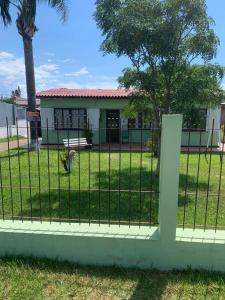 a fence in front of a house at Casa de alquiler M g in Pântano Grande