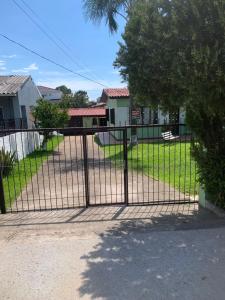 a gate in front of a yard with houses at Casa de alquiler M g in Pântano Grande