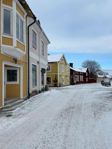 a snow covered street in a town with houses at New Central Apartment in Östhammar