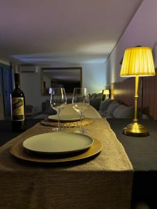 a table with a plate and two wine glasses on it at SuitePoolBarcelona in Vilassar de Dalt