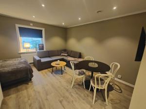 a living room with a couch and a table and chairs at New Central Apartment in Östhammar