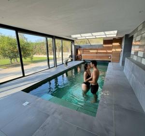 two people sitting in a swimming pool in a house at SuitePoolBarcelona in Vilassar de Dalt