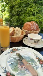 a table with plates of bread and a glass of orange juice at Ferme Mellon in Niederbronn-les-Bains +16 photos