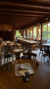 a dining room with tables and chairs and windows at Ferme Mellon in Niederbronn-les-Bains