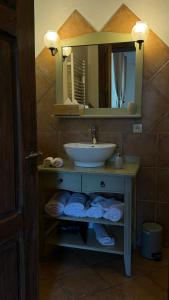 a bathroom with a sink and a mirror and towels at Ferme Mellon in Niederbronn-les-Bains
