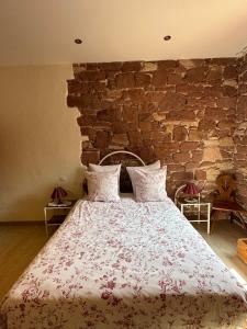 a bedroom with a large bed with a brick wall at Ferme Mellon in Niederbronn-les-Bains